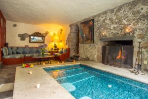 a living room with a swimming pool and a fireplace at Hacienda San Gabriel de las Palmas in Amacuzac