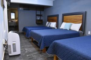 a hotel room with two beds with blue sheets at Hotel Casa 20 in León