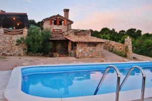 a house with a swimming pool in front of a building at Boutique B&B Agroturizam Sv. Juraj in Krk