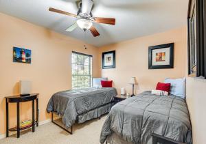 Un dormitorio con dos camas y un ventilador de techo. en Cozy Bungalow Steps from Downtown Mount Dora, en Mount Dora