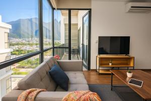 a living room with a couch and a television at Moderno Ubicacion Vistas Seguridad y Estilo in Monterrey +33 photos