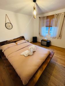 a large bed in a bedroom with a clock on the wall at Conacul Perla Bratiei in Cîndeşti +43 photos