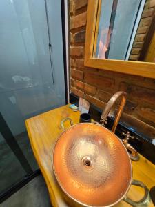 a sink in a bathroom with a wooden counter at Cabana Fé Miguel Pereira Chalé Para Casal no Centro MP in Miguel Pereira