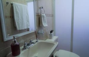 Un baño con lavabo, inodoro y espejo. en Departamentos "GARCÍA LÓPEZ" es amplio muy acogedor 2 dormitorios y cerca del Auditorio Guelaguetza, en Oaxaca City 36 fotos más