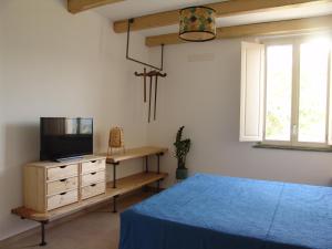 a bedroom with a bed and a tv on a dresser at Il Casino di Donna Maria in Mormanno