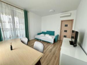 a room with a table and a couch and a bed at AVIATORII Modern Escape Apartment in Constanţa