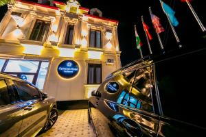 塔什干Centrum Hotel Tashkent的一辆停在建筑物前的汽车，上面挂着旗帜