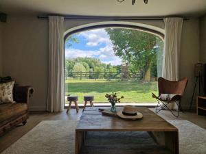 a living room with a large window and a table at Muntershof in Velzeke-Ruddershove