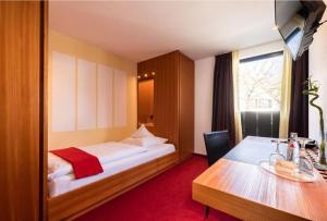 ein Hotelzimmer mit einem Bett und einem Tisch in der Unterkunft Hotel Antoniushütte in Balve