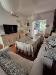 ein Wohnzimmer mit Tisch und Couch in der Unterkunft Casa en Loma Sancti Petri a 900 m de la playa de La Barrosa in Chiclana de la Frontera + 18 Fotos