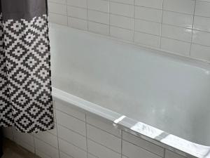 una vasca bianca in un bagno con una tenda da doccia bianca e nera di Bears View BB a Berna Altre 17 foto