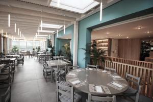 a dining room with tables and chairs and windows at Hosteria,restaurante,cafeteria Los Abetos in Villanueva de la Peña