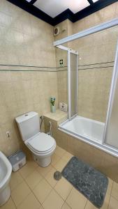 a bathroom with a toilet and a tub and a sink at Kasa Kastelo by Férias in Figueira in Figueira da Foz
