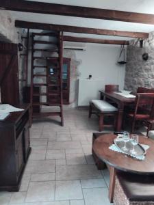 a living room with a table and a spiral staircase at Mani Fort Charabos in Stavríon