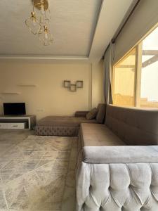 a living room with a couch and a large window at Coronado Dabaa Beach in Zāwiyat ‘Abd al Mun‘im