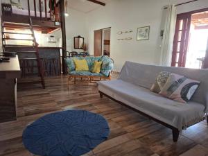 ein Wohnzimmer mit Sofa und Tisch in der Unterkunft Casa Vista Baepi - Estilo Boho, Mais Streaming a 1,5km da Balsa in Ilhabela + 32 Fotos