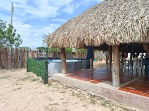 una cabaña con jacuzzi y techo de hierba en Hostal CQ Camarones, en Camarones