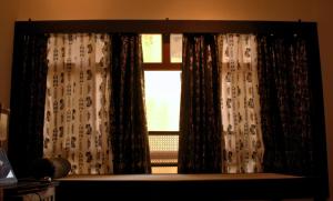 a window with curtains in a living room at The Bird House in Ukunda Airport +6 photos