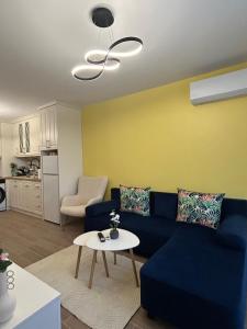 a living room with a blue couch and a table at Sinemorets Blue apartments in Sinemorets