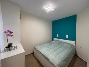 a bedroom with a bed with a blue accent wall at Sinemorets Blue apartments in Sinemorets