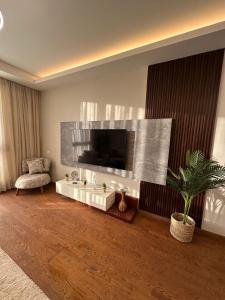 Una sala de estar con un televisor en la pared. en Jamila Home - Aeon Towers - 704 - Mall of Arabia -Zayed, en Sheikh Zayed