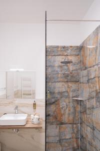 a bathroom with a sink and a glass shower at Carrera Living Family Apartments in Borgomanero