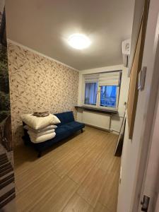 a living room with a blue couch and a window at Palace of Culture Skyline in Warsaw