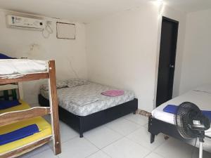 Habitación pequeña con 2 literas y ventilador. en Hostal CQ Camarones, en Camarones