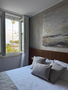 a bedroom with a white bed with a window at Salsedine affittacamere in Grottammare