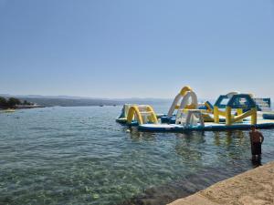 a man standing in the water next to a water slide at Leona's paradise in Opatija