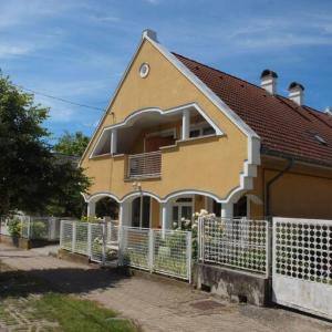 a yellow house with a white fence in front of it at Yellow Rose in Balatongyörök