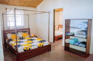 a bedroom with a bed and a mirror at chez Leo in Tuléar