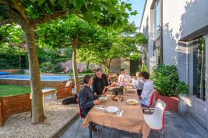 a group of people sitting at a table on a patio at De Visitatie Rupelmonde in Rupelmonde