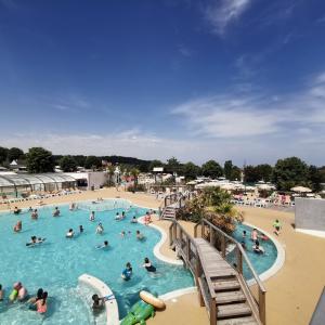 a group of people in a swimming pool at a resort at Houlgate-154- Mobilhome cosy 4 personnes Camping 5 étoiles in Houlgate