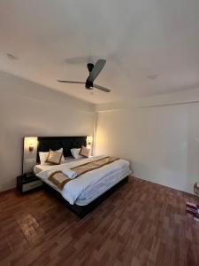 a bedroom with a bed with a ceiling fan at Hotel The Kargil Castle in Kargil
