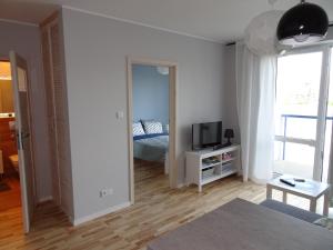 a living room with a bed and a television at Nova Apartament in Białystok