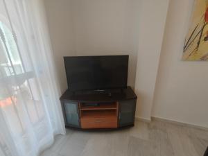 Un televisor de pantalla plana colocado sobre un soporte en una habitación. en Nerja Sun Apartments Casa Cipreses 4, en Nerja