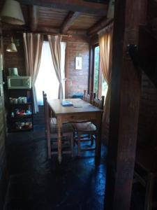 Un comedor con mesa y sillas de madera. en Cabañas Las Lumas Esquel, en Esquel