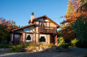 a log cabin with a porch and a balcony at Cabañas Las Lumas Esquel in Esquel