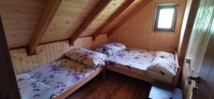 two beds in a wooden cabin with a window at Villa Besi Bogë-Rugovë in Mazgit +8 photos