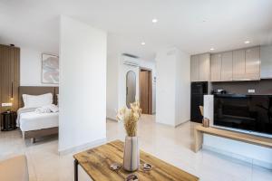 a living room with a television and a living room with a table at Unicos City Suites in Kos Town