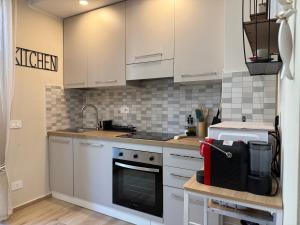 a kitchen with white cabinets and a stove top oven at SeaLaVie in Savona +12 photos