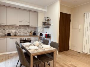 a kitchen with a wooden table and chairs in a room at SeaLaVie in Savona