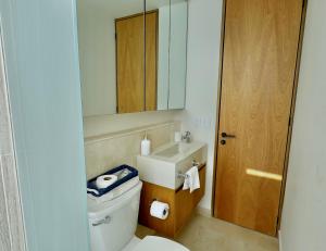 a bathroom with a toilet and a sink and a mirror at Beachfront Studio at Zantamar in Cruz de Huanacaxtle