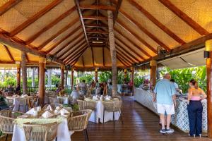a restaurant with white tables and chairs and people at Kovay Gardens in Cruz de Huanacaxtle