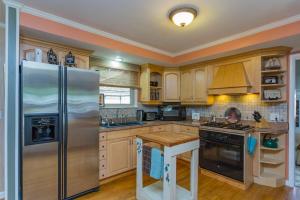 a kitchen with a stainless steel refrigerator and wooden cabinets at The Place Between The Lakes 4 Bedrooms 4 Beds in Old Hickory