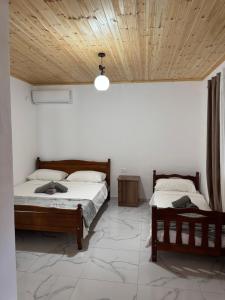 a bedroom with two beds and a wooden ceiling at Xhoen Haven in Shkodër
