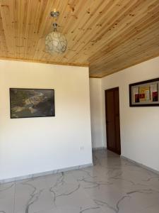 a room with white walls and a wooden ceiling at Xhoen Haven in Shkodër +10 photos