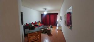 a living room with a couch and a red curtain at Porte Hotel in Az Za‘farānah