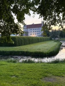 a house on a hill with a river in front at private room central in Güstrow